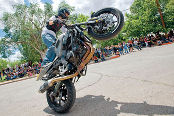 Ernie Vigil performs a wheelie for a crowd of spectators at a motorcycle stunt show during the Fire and Ice Motorcylce Rally in Grants Saturday. © 2011 Gallup Independent / Cable Hoover 